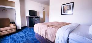 a hotel room with a bed and a flat screen tv at Helena Inn - Airport in Helena