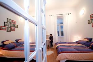 een vrouw in een kamer met vier bedden bij CentrÁlom Apartman in Pécs +18 foto's