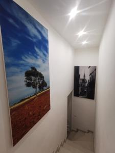a hallway with two paintings on the wall at Holiday House in Nardò