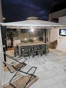 a table and chairs on a patio at night at Holiday House in Nardò