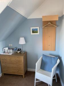 una camera blu con una sedia e un comò di Honeypot Guest House a Crail