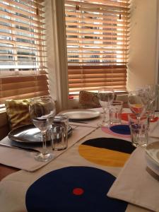 a table with wine glasses and plates on it at Two Top Central Unique Artisan Beach Studios - also separate spa cabin in Brighton & Hove