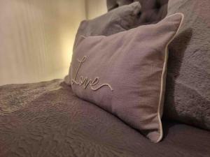 a pillow with the word live written on it on a bed at Bournemouth Luxury Hot Tub 1 Bed Garden Flat in Bournemouth