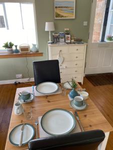 a wooden table with plates on top of it at Honeypot Guest House in Crail