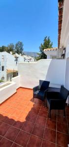 a patio with two chairs and a table on a roof at Mijas Holiday in Fuengirola