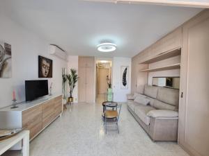 salon z kanapą, telewizorem i stołem w obiekcie Agua Mundo studio w mieście Benidorm