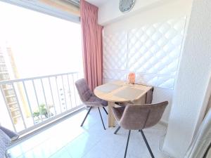 mały stół i 2 krzesła w pokoju z oknem w obiekcie Agua Mundo studio w mieście Benidorm