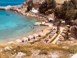 a beach with umbrellas and people in the water at Villa Bellina in Pefki