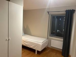 ein kleines Schlafzimmer mit einem Bett und einem Fenster in der Unterkunft 4-Bedroom-Apt for 7/Oslo Central in Oslo
