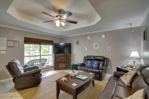 a living room with leather furniture and a ceiling fan at Charming Family Cottage Near Pass Christian Beach! in Pass Christian