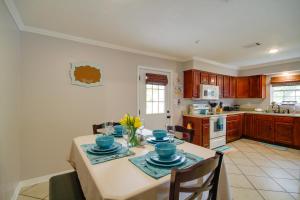 a kitchen with a table with blue dishes on it at Charming Family Cottage Near Pass Christian Beach! in Pass Christian