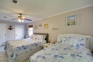 a bedroom with two beds and a ceiling fan at Charming Family Cottage Near Pass Christian Beach! in Pass Christian
