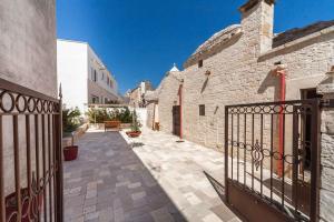a courtyard of a building with a wrought iron gate at La corte di Ercole in Alberobello