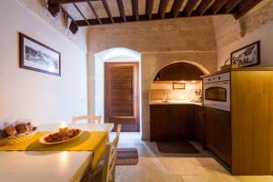 a kitchen with a table and a dining room at La corte di Ercole in Alberobello