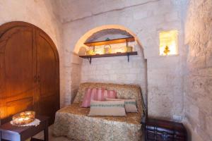 a bedroom with a bed in a stone wall at La corte di Ercole in Alberobello
