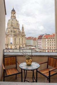 a table on a balcony with a view of the city at Luxury Home / 3-Raum-Suite an der Frauenkirche / 6 in Dresden