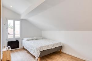 Habitación blanca con cama y ventana en Lovely flat in the center of Argenteuil - Welkeys, en Argenteuil