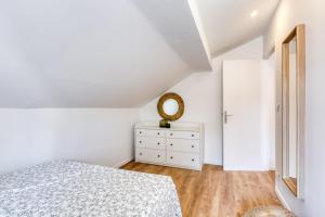 Habitación blanca con cama y espejo en Lovely flat in the center of Argenteuil - Welkeys, en Argenteuil