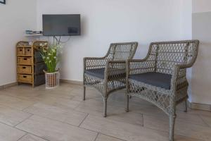 two wicker chairs and a television in a room at Studio Apartment in Crikvenica II in Dramalj