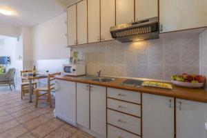 a kitchen with white cabinets and a bowl of fruit on the counter at Studio Apartment in Crikvenica II in Dramalj