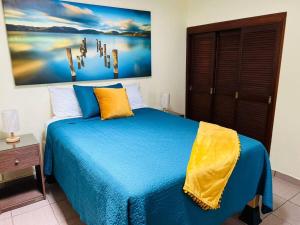 a bedroom with a blue bed and a painting on the wall at Residencia Ibarra in Santa Cruz de la Soledad