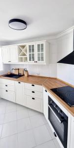 a white kitchen with white cabinets and a stove at Mijas Holiday in Fuengirola