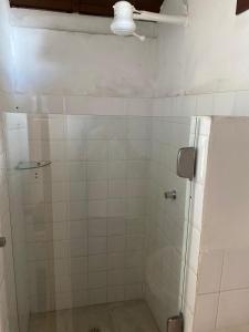 y baño con ducha de azulejos blancos. en Pousada Jardim das Bromélias, en Arraial d'Ajuda