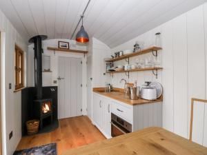a kitchen with a stove and a fireplace at Little Hut in Weston-super-Mare