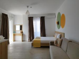 a hotel room with a bed and a couch at Iris Apartments Ksamil in Ksamil