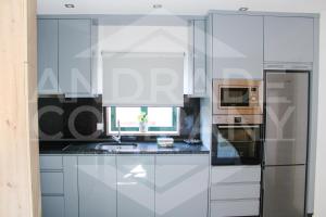 a kitchen with white cabinets and a stainless steel refrigerator at Casa da Padaria Antiga 2 in Pinhão