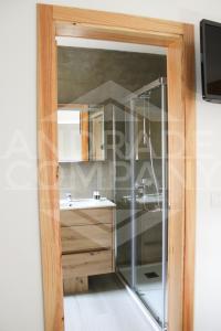 a bathroom with a glass shower and a sink at Casa da Padaria Antiga 2 in Pinhão