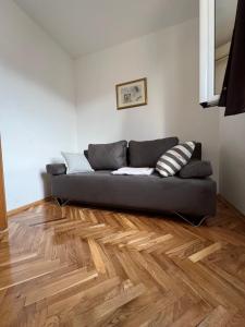 sala de estar con sofá en el suelo de madera en Ksenia Guesthouse Apartments and Studios en Budva