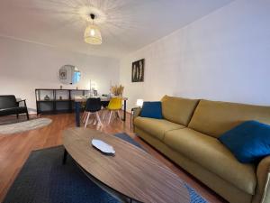 a living room with a couch and a table at Colomiers Shelter - City, Terrasse, Wifi, Netflix in Colomiers