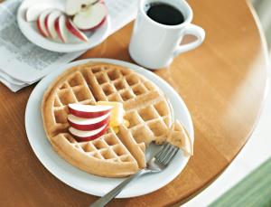 une assiette avec une gaufre, des pommes et une tasse de café dans l'établissement SpringHill Suites by Marriott Franklin Cool Springs, à Franklin