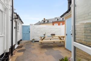 a patio with a wooden picnic table on a white wall at 9 Riverside in Sidmouth