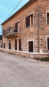 um grande edifício de tijolos com janelas e uma varanda em Casa Ditta em Mela