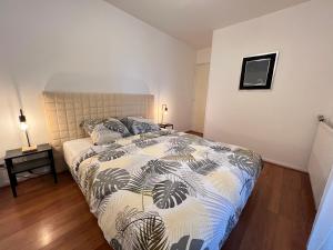 a bedroom with a bed with a comforter on it at Colomiers Shelter - City, Terrasse, Wifi, Netflix in Colomiers