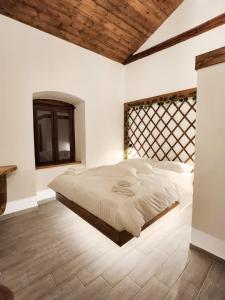 a bedroom with a large bed and a wooden ceiling at Èlia Luxury Rooms in Areopoli