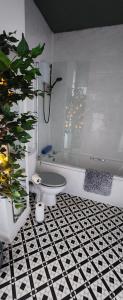 een badkamer met een bad en een zwart-witte tegelvloer bij Flat 7 Buxton Market Place Apartment in Buxton