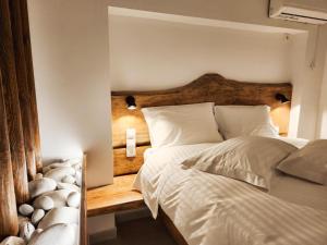 a bedroom with a large bed with a wooden headboard at Èlia Luxury Rooms in Areopoli