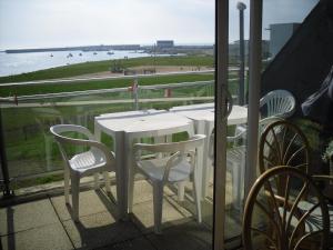 een tafel en stoelen op een balkon met uitzicht op de oceaan bij Océan in Penmarcʼh