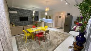 塔什坎的住宿－Duplex80，厨房以及带黄色桌椅的用餐室。