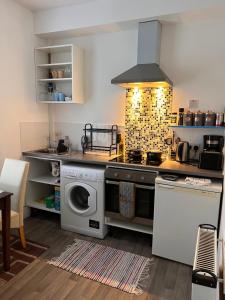 a kitchen with a stove and a washing machine at Lovely - 1 Bedroom Flat in Hastings Town Centre in Hastings
