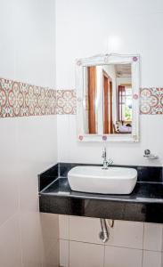 a bathroom with a sink and a mirror at Flats Casa de Violeta in Tiradentes