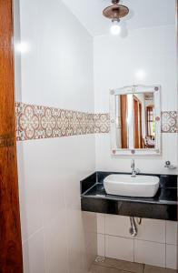 a bathroom with a sink and a mirror at Flats Casa de Violeta in Tiradentes