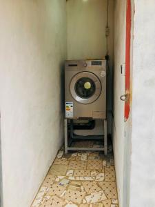 eine schmutzige Waschküche mit Waschmaschine in einem Zimmer in der Unterkunft Chez Catherine et Gabriel in Bangui