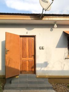 Chez Catherine et Gabriel في بانغي: باب خشبي على جانب المبنى
