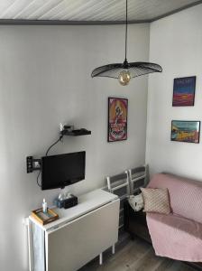 a living room with a tv and a couch at La Casita: Studio cosy indépendant de 25 m² in Les Sables-dʼOlonne