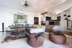 a living room with a couch and two ottomans at Blue View Amazing 3-Bedroom, Sea View Villa, in Koh Tao