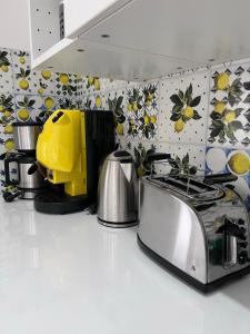 a kitchen with a stove and a yellow appliance at Villa Somma Apartments in Pimonte